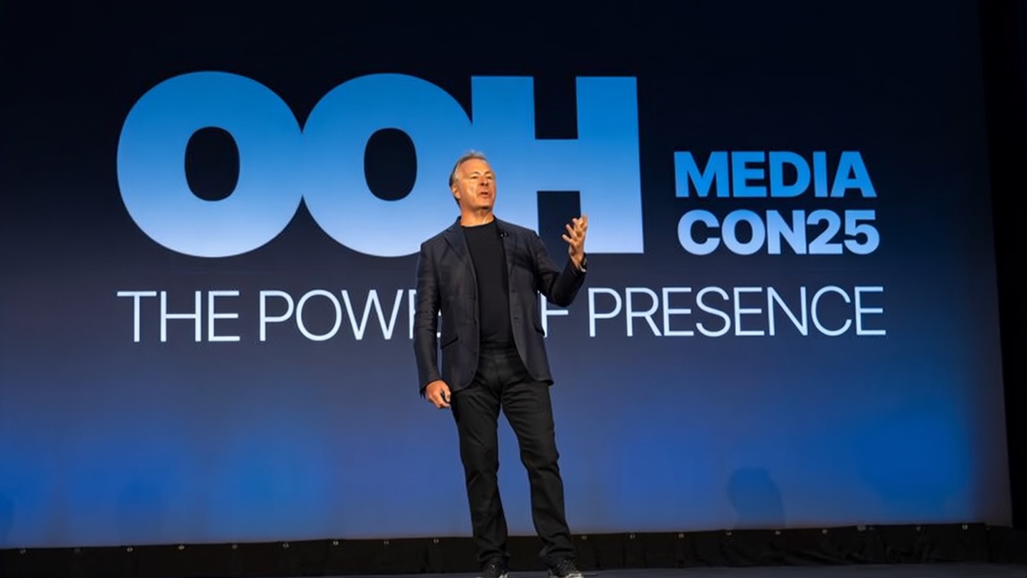 Nick Brien speaking onstage at the 2025 OOH Media Conference, under the words The Power of Presence