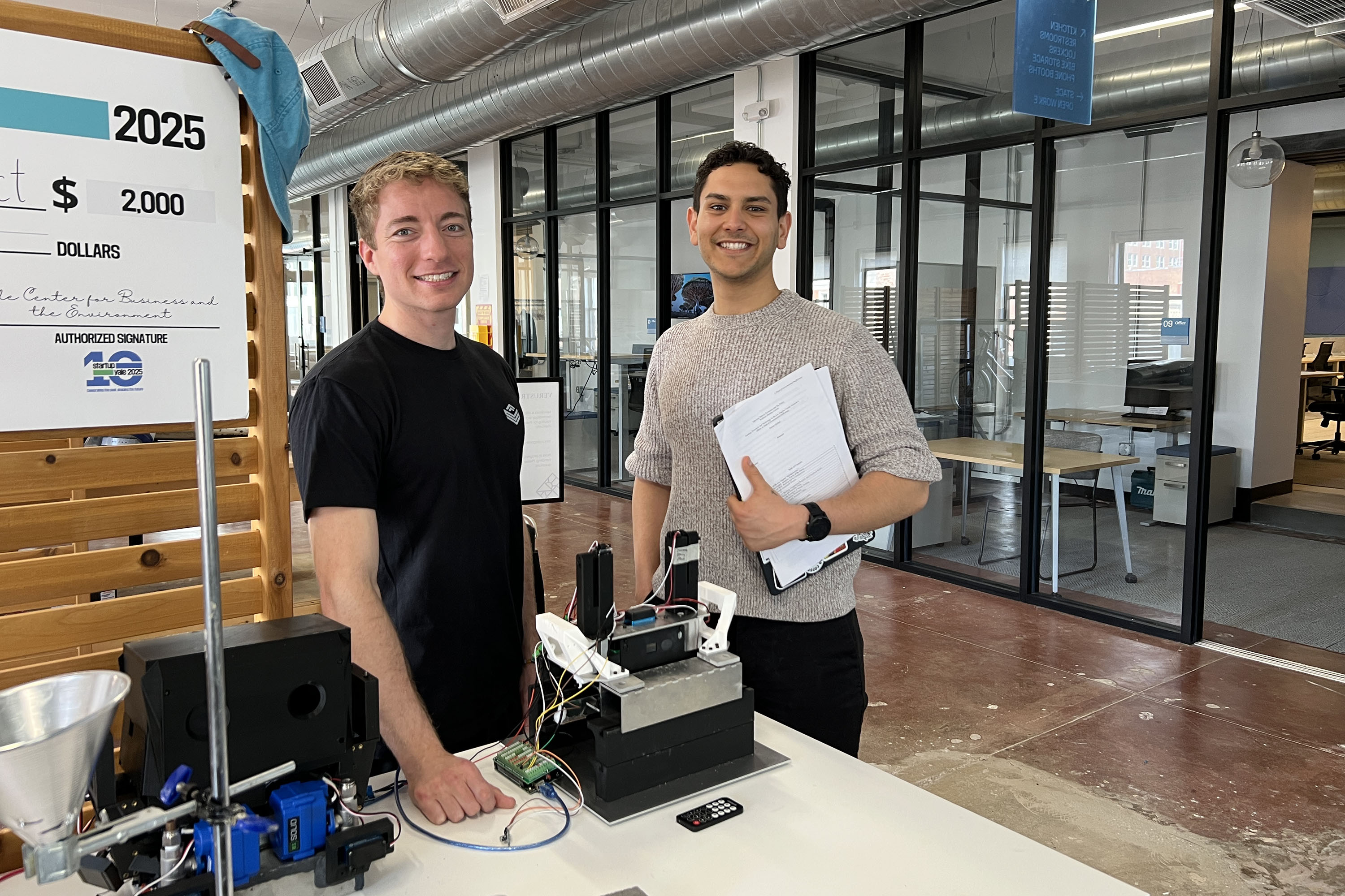 Nick Callegari on the left and Sam Haddad on the right standing with a small-scale printer in a workshop