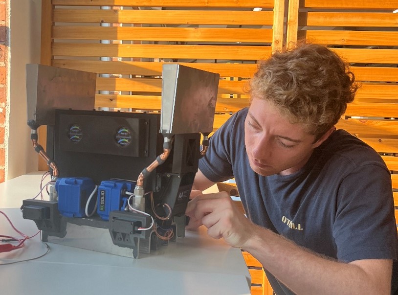 Nick Callegari working at a table with an early construction printer