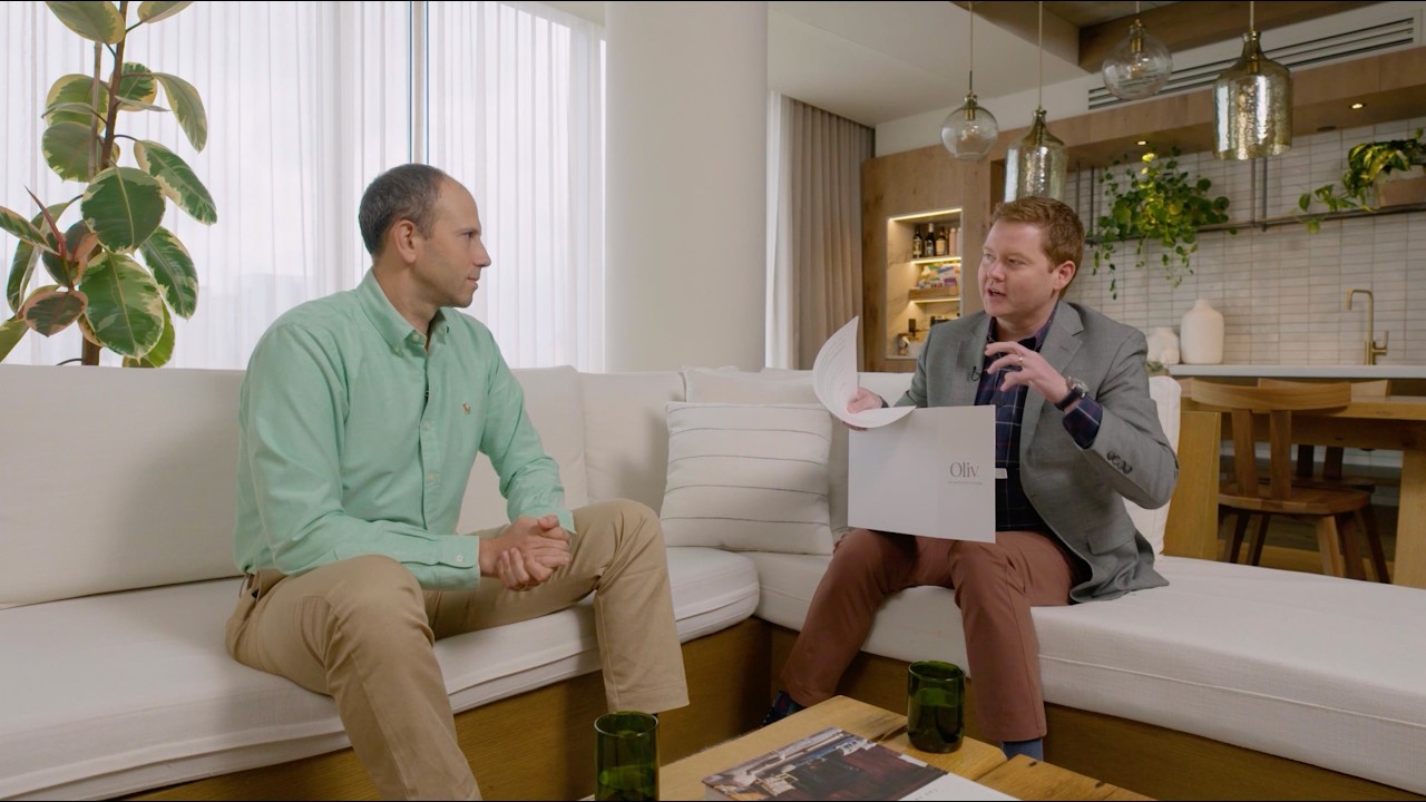 Nick Greenfield, left, in a seated interview with Kyle Fagala, who holds an Oliv folder.
