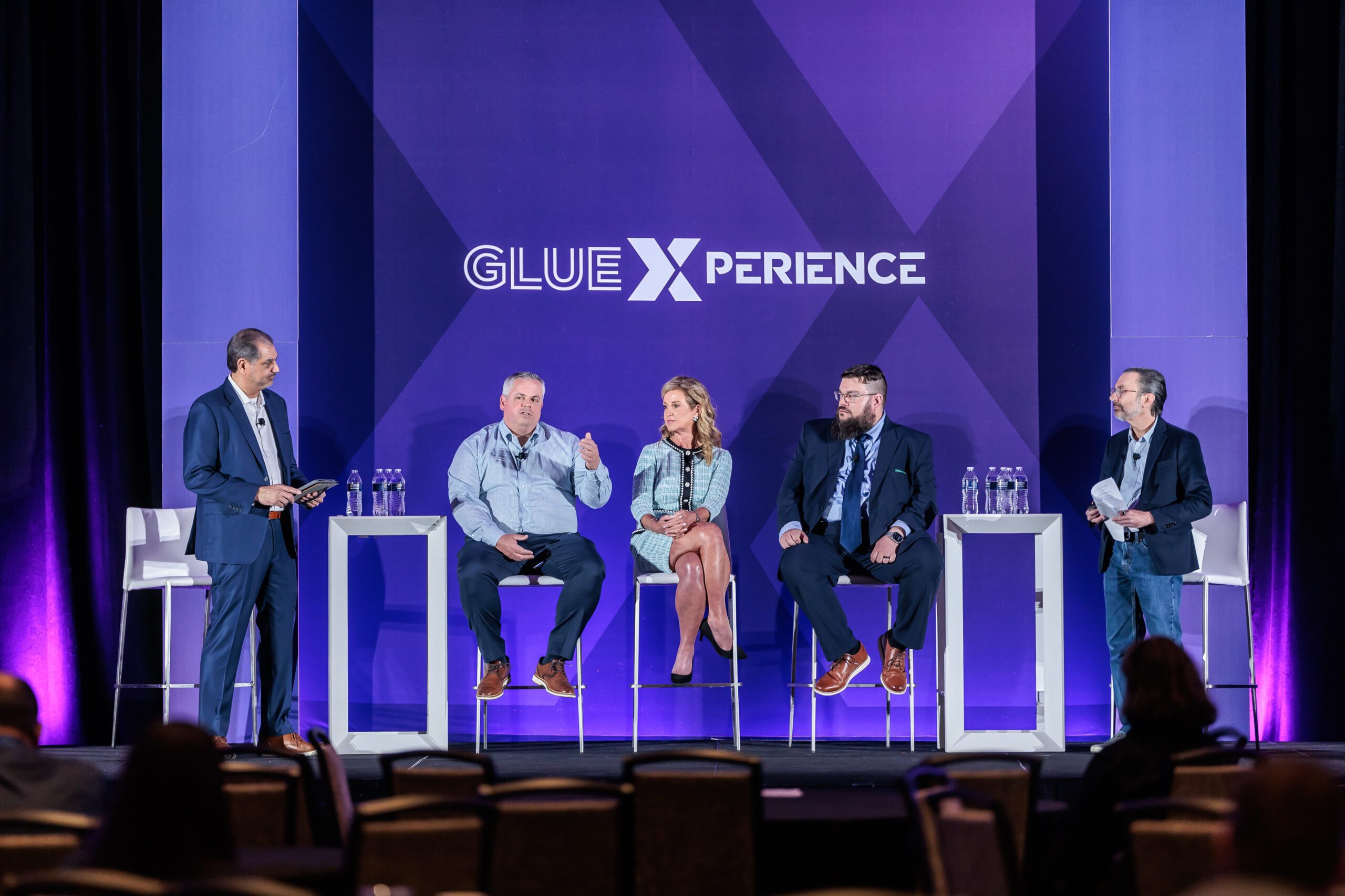 Nick Recker, second from left, speaking with four fellow panelists on the GlueXperience stage