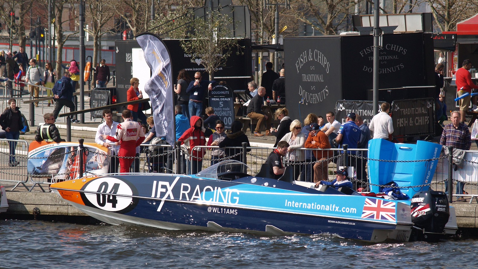 IFX Racing boat number 04 at Royal Victoria Dock, with its crew aboard and spectators on the quayside