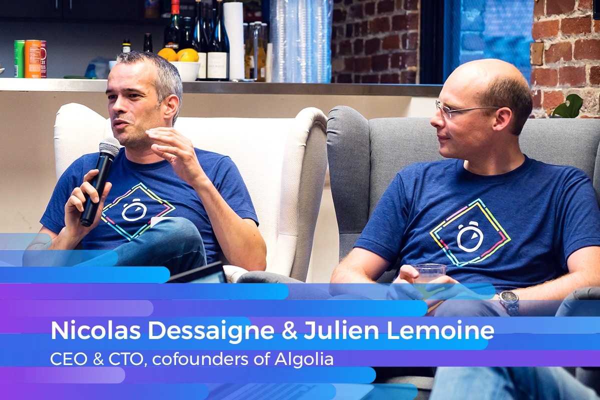 Dessaigne speaking into a microphone while Lemoine listens beside him