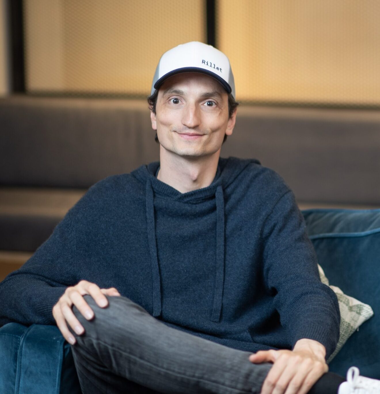 Nicolas Kopp seated in an office wearing a Rillet cap and dark sweater