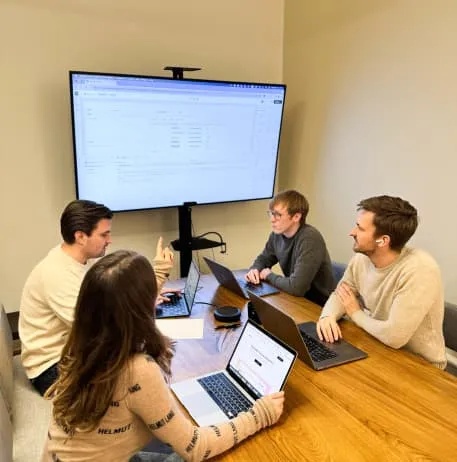 The turian team working together around a meeting table with laptops