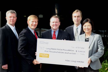 Nien-Ling Wacker, at right, with Chris Wacker and Long Beach police and foundation representatives holding a donation check
