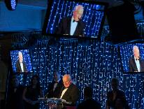 Archival view of the 2015 Manchester Legal Awards stage, with Michael Redfern QC speaking and Nigel Wright and Bernadette Bennett looking on