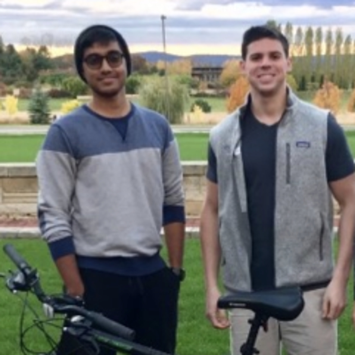 A young Nikhil Bharadwaj and Alexander Isaacson standing beside electric bicycles at Penn State