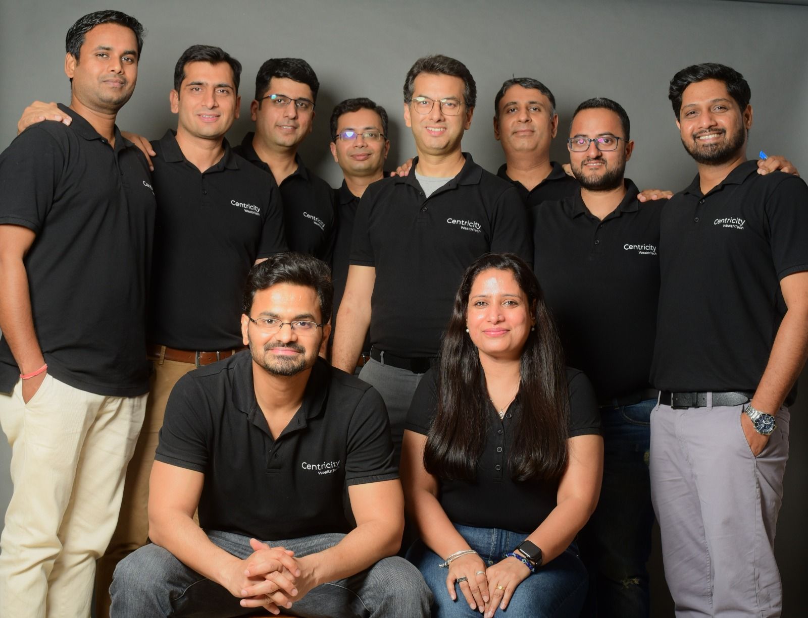 Centricity founding team posing together in black company polo shirts