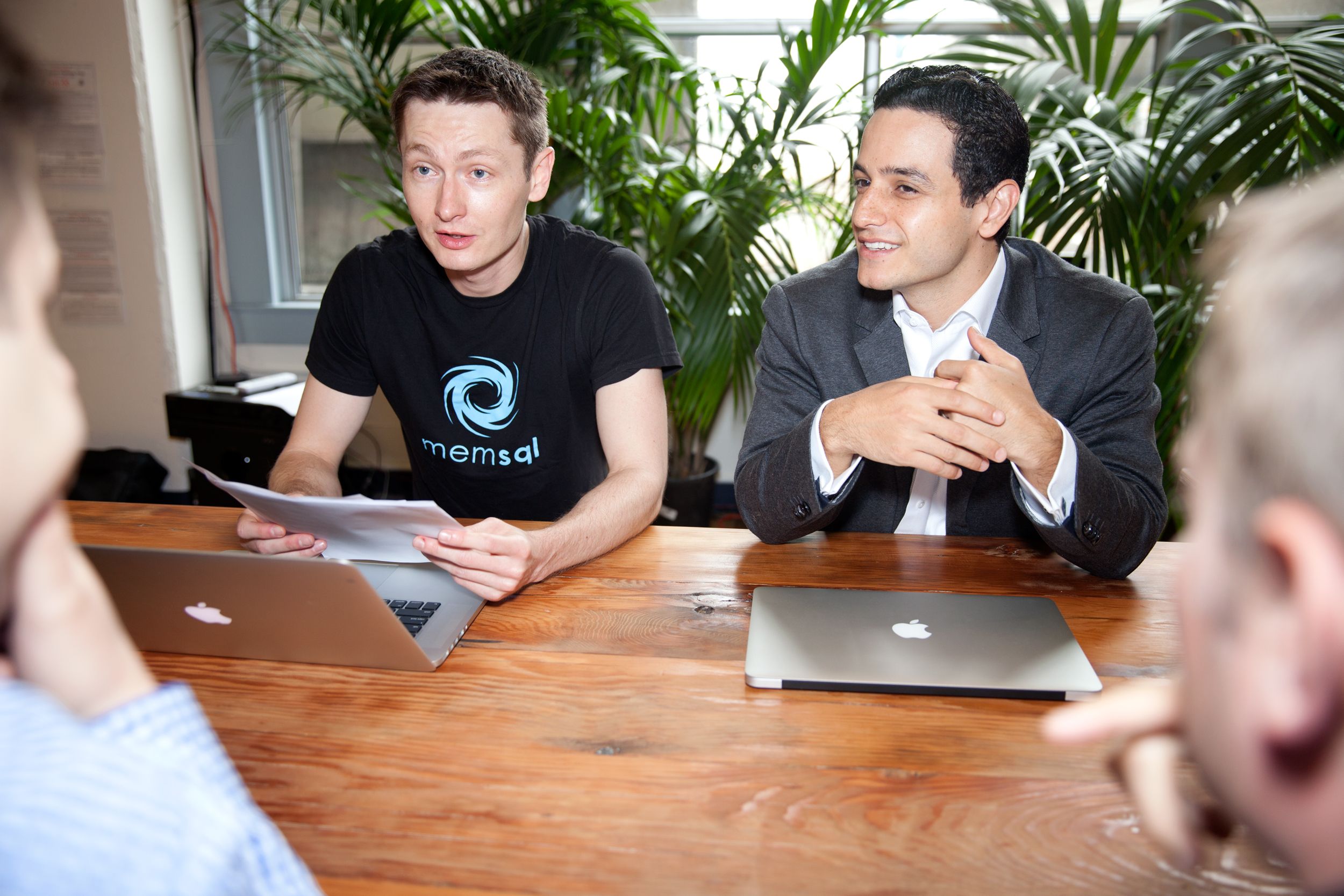 Nikita Shamgunov, left, and Eric Frenkiel seated at a table with a laptop and papers