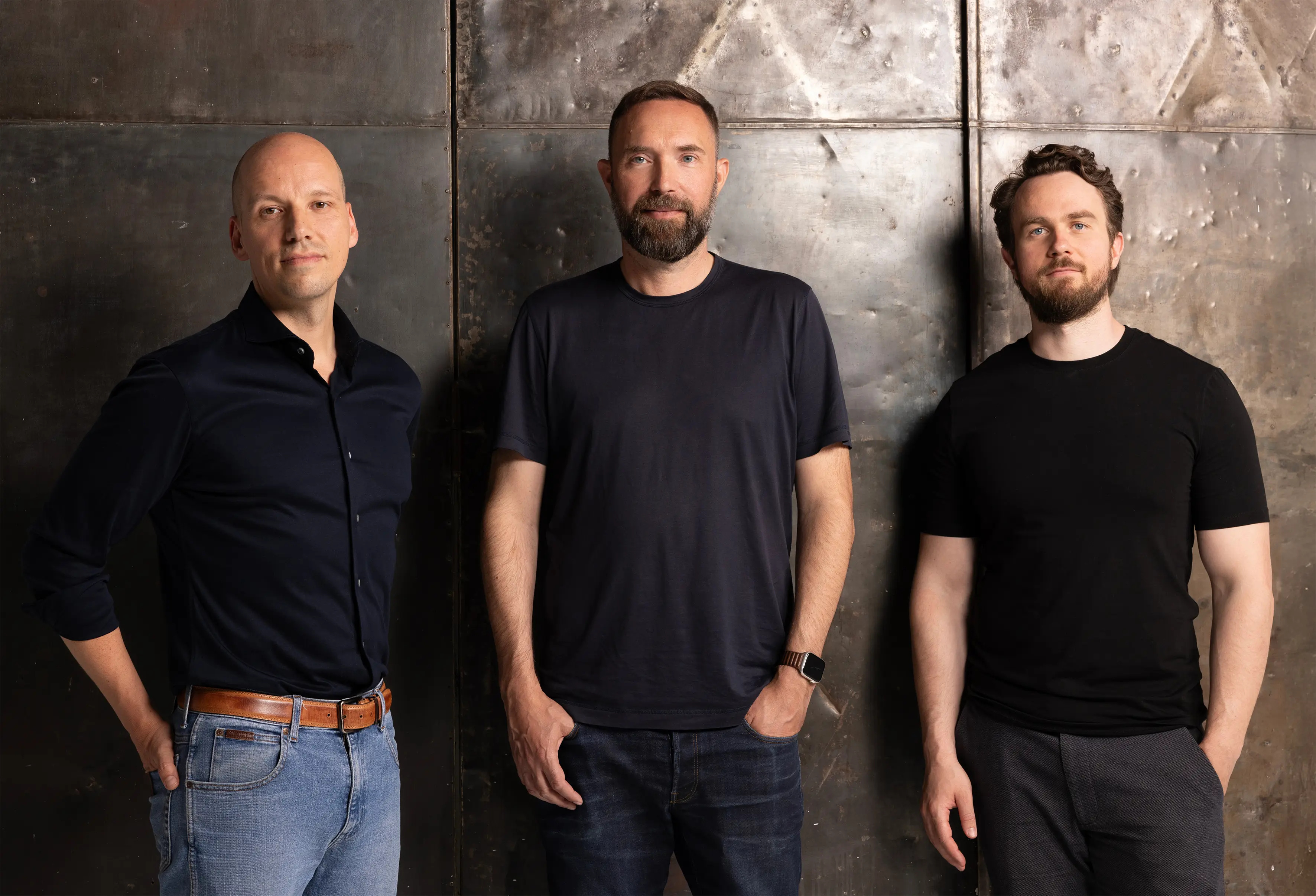 Helsing co-founders Gundbert Scherf, Torsten Reil and Niklas Köhler standing together against a metal wall