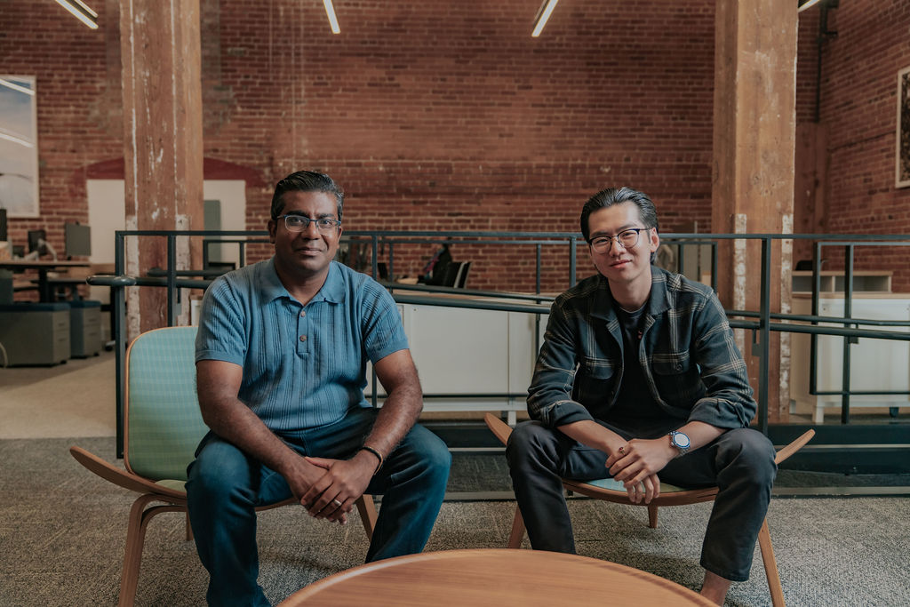 Nilam Ganenthiran seated beside a member of the Haize Labs team in Beacon’s brick-walled office