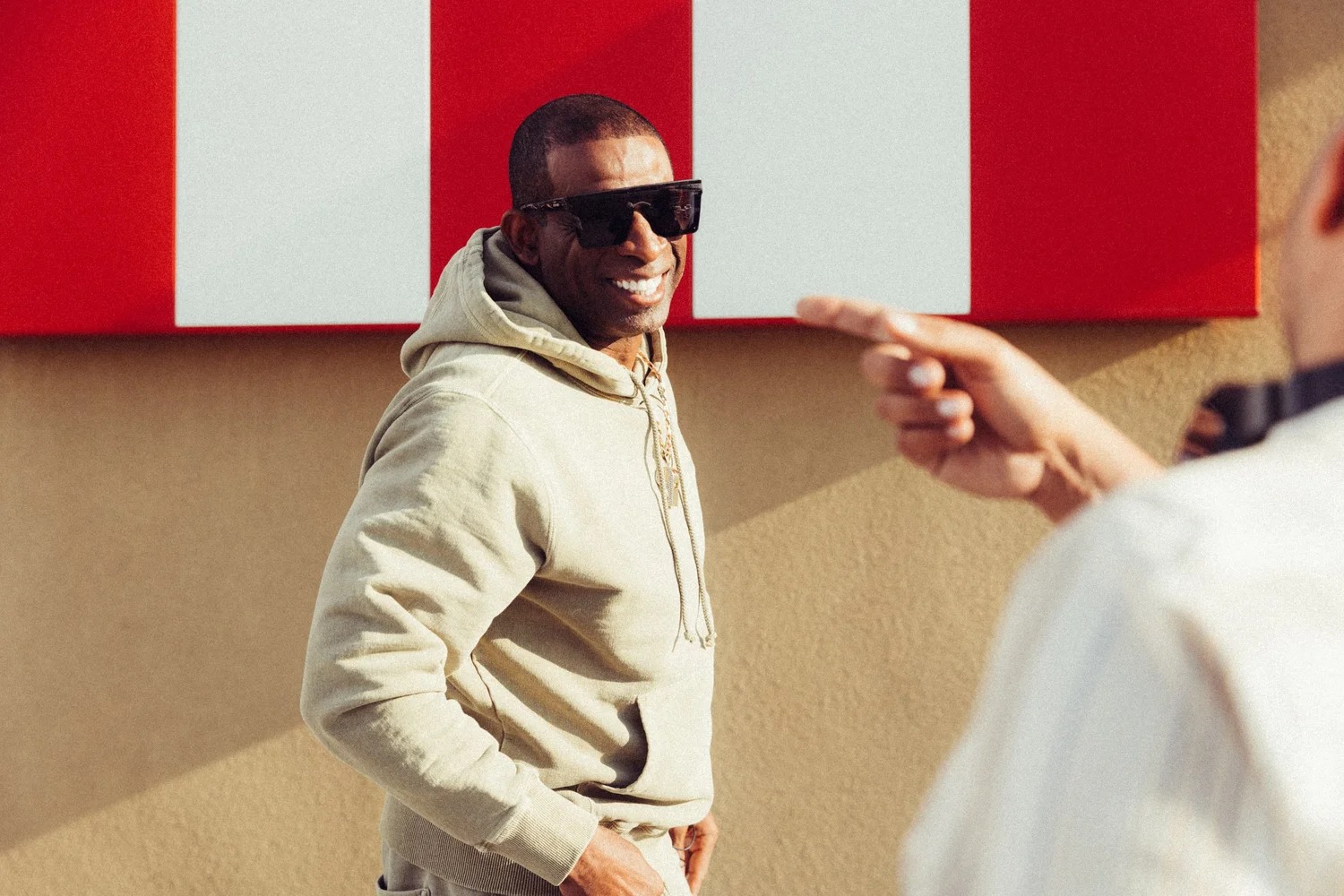 Deion Sanders smiling on the set of a KFC campaign