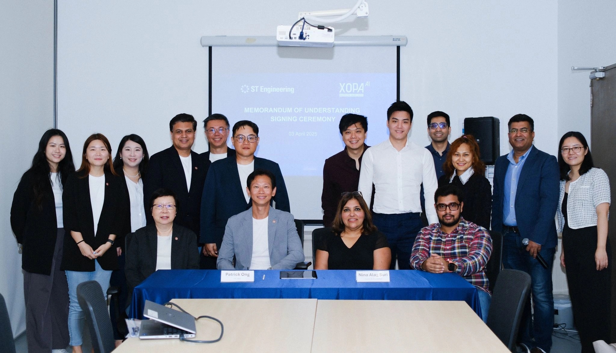 Nina Alag Suri seated with colleagues at an ST Engineering and X0PA AI memorandum-of-understanding signing ceremony