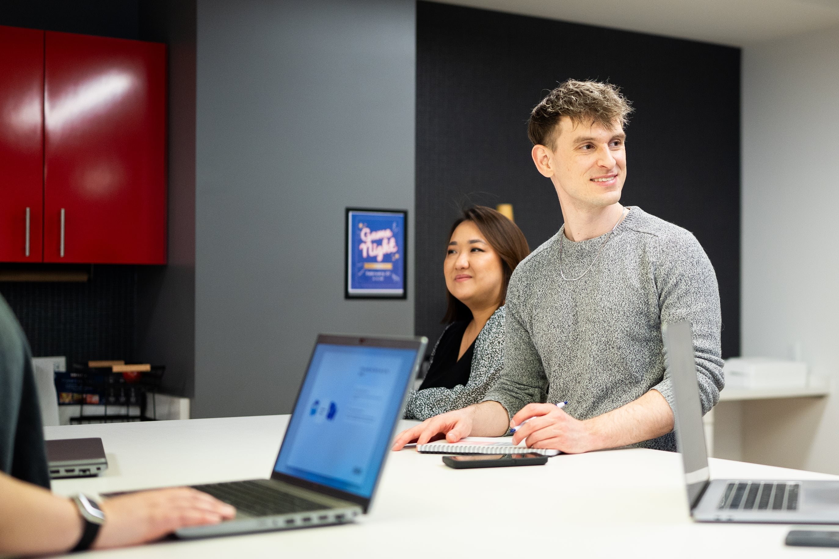 NinjaTrader colleagues gathered around laptops in an office