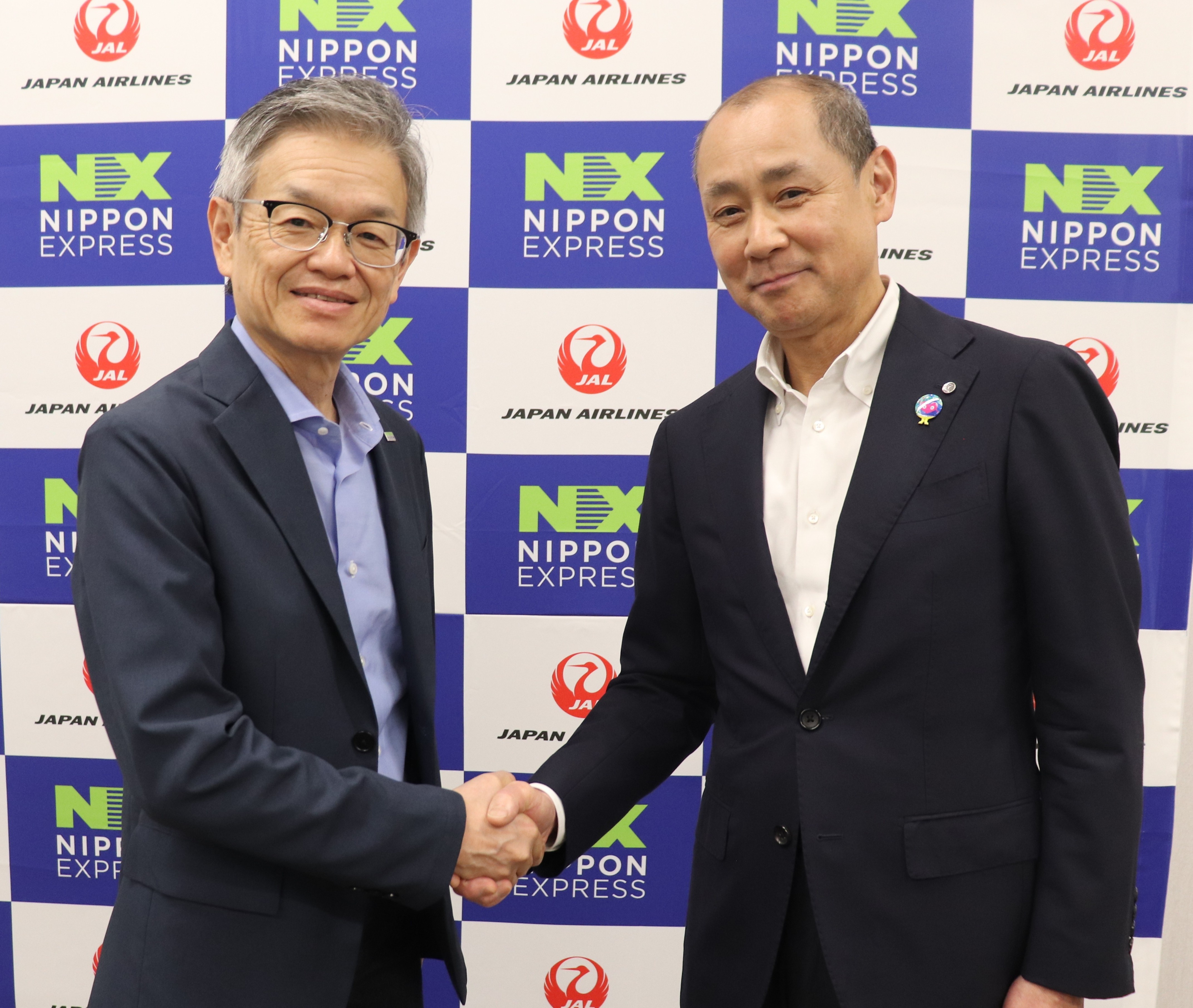 Representatives of NX Group and Japan Airlines shake hands at the transport partnership announcement