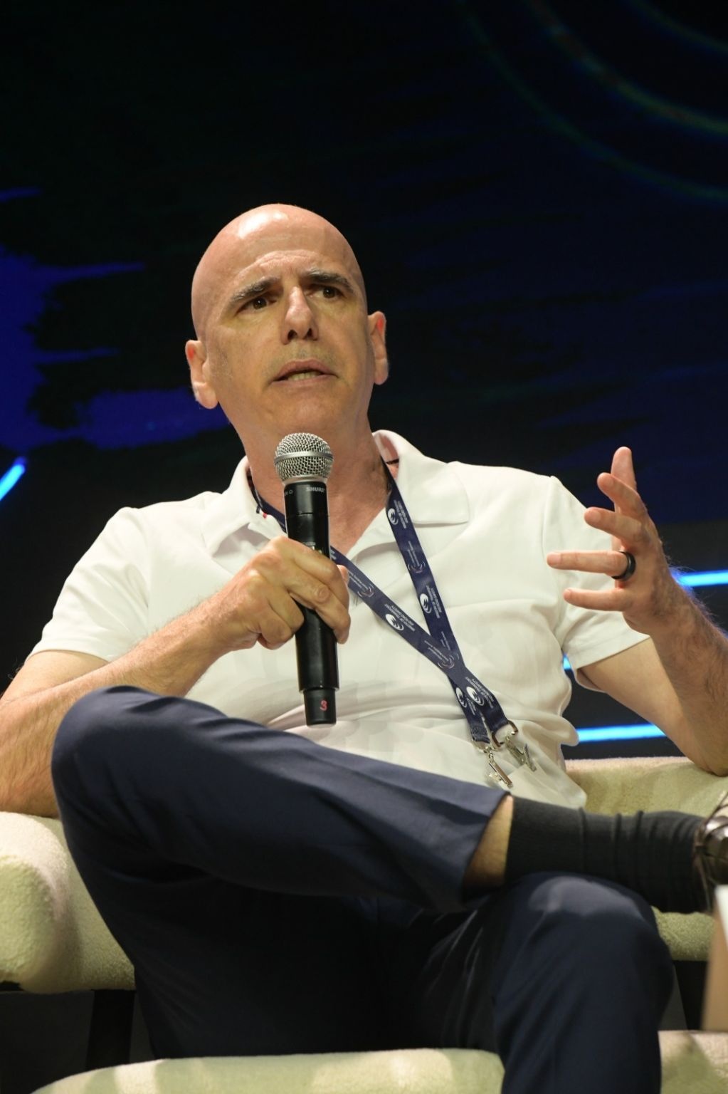 Nir Bezalel speaking into a microphone and gesturing during the 2026 summit panel