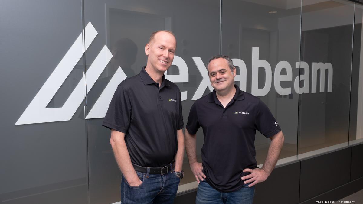 Michael DeCesare, left, and Nir Polak, right, standing beside the Exabeam logo.