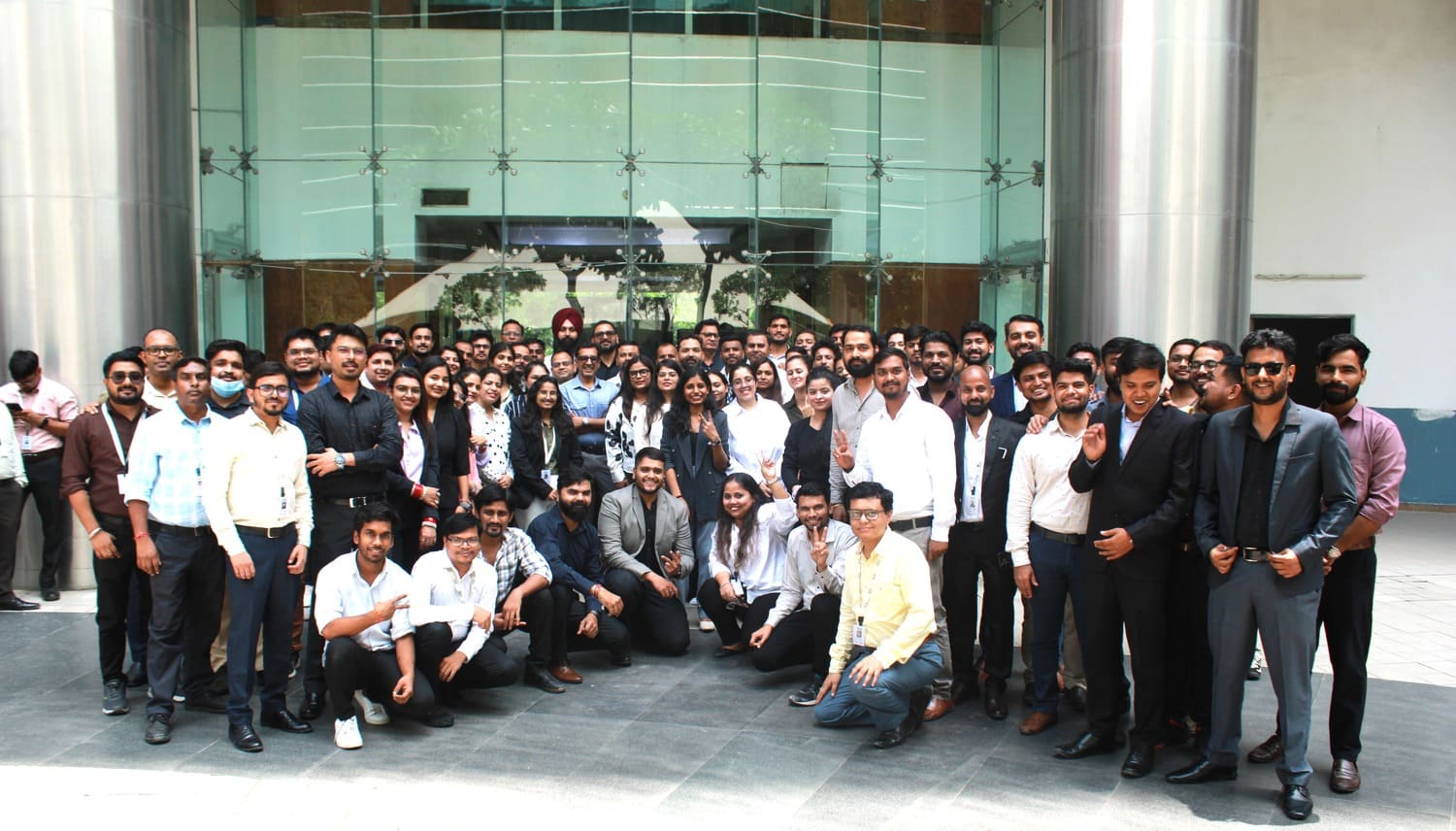 NITS Solutions team gathered outside a glass-fronted building