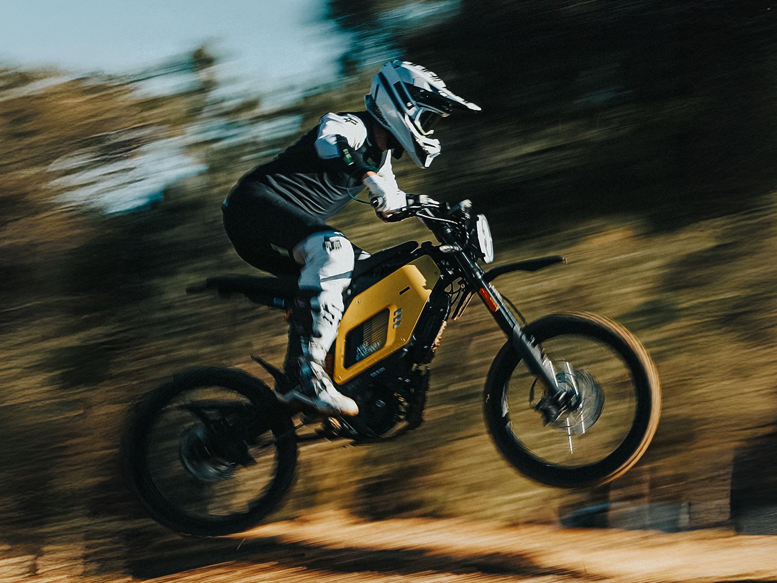 Rider in protective gear riding a yellow NIU electric off-road motorcycle