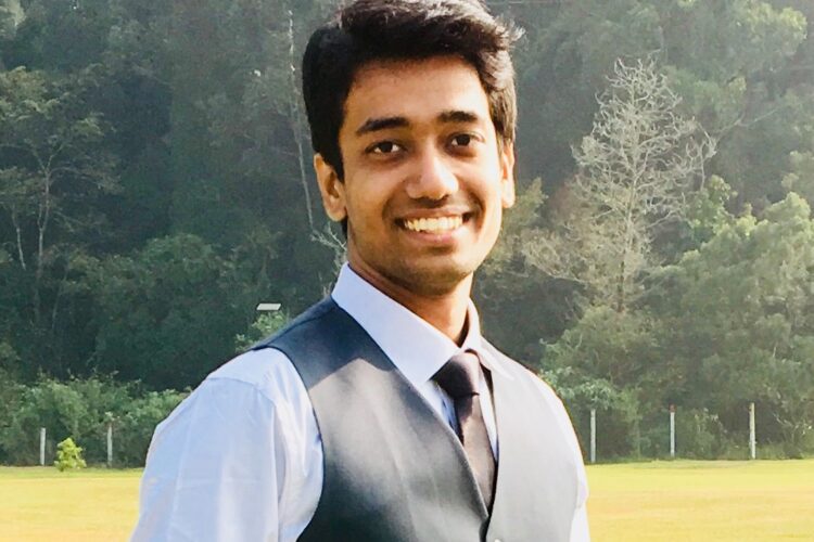 Niwin Santhosh outdoors, wearing a shirt, tie and waistcoat