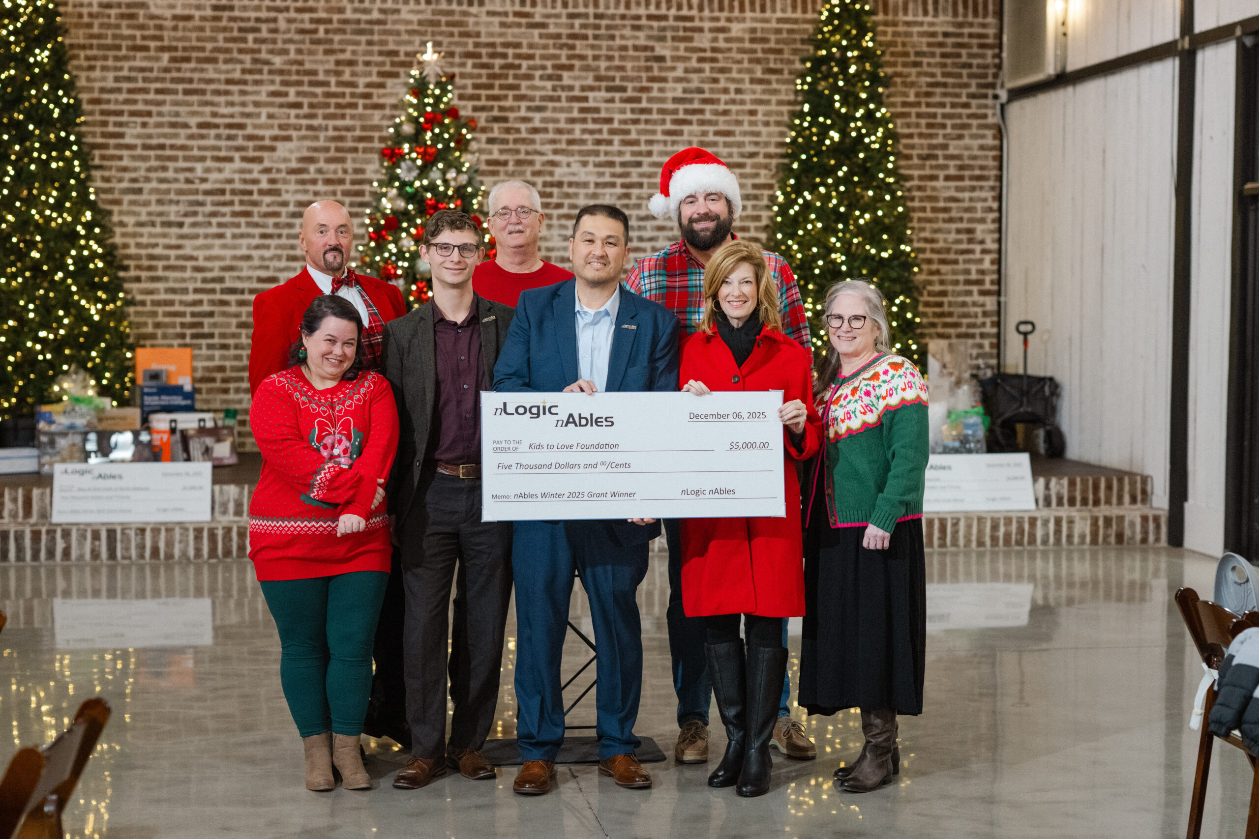 nLogic nAbles grant presentation to Kids to Love, with a check dated December 6, 2025