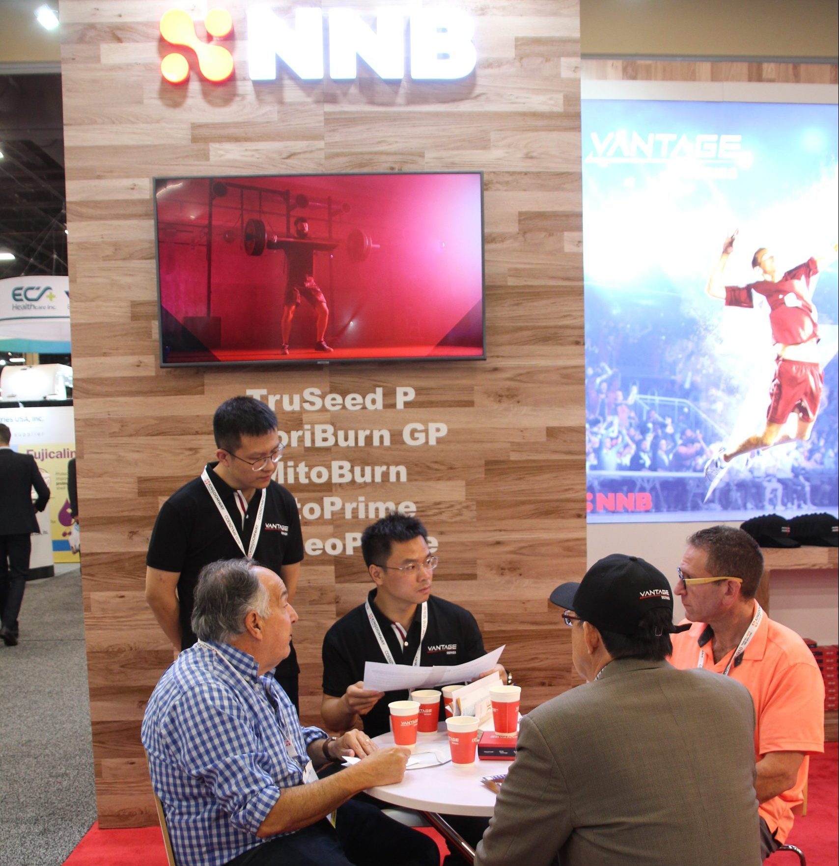NNB representatives and visitors discussing ingredients at a trade-show table
