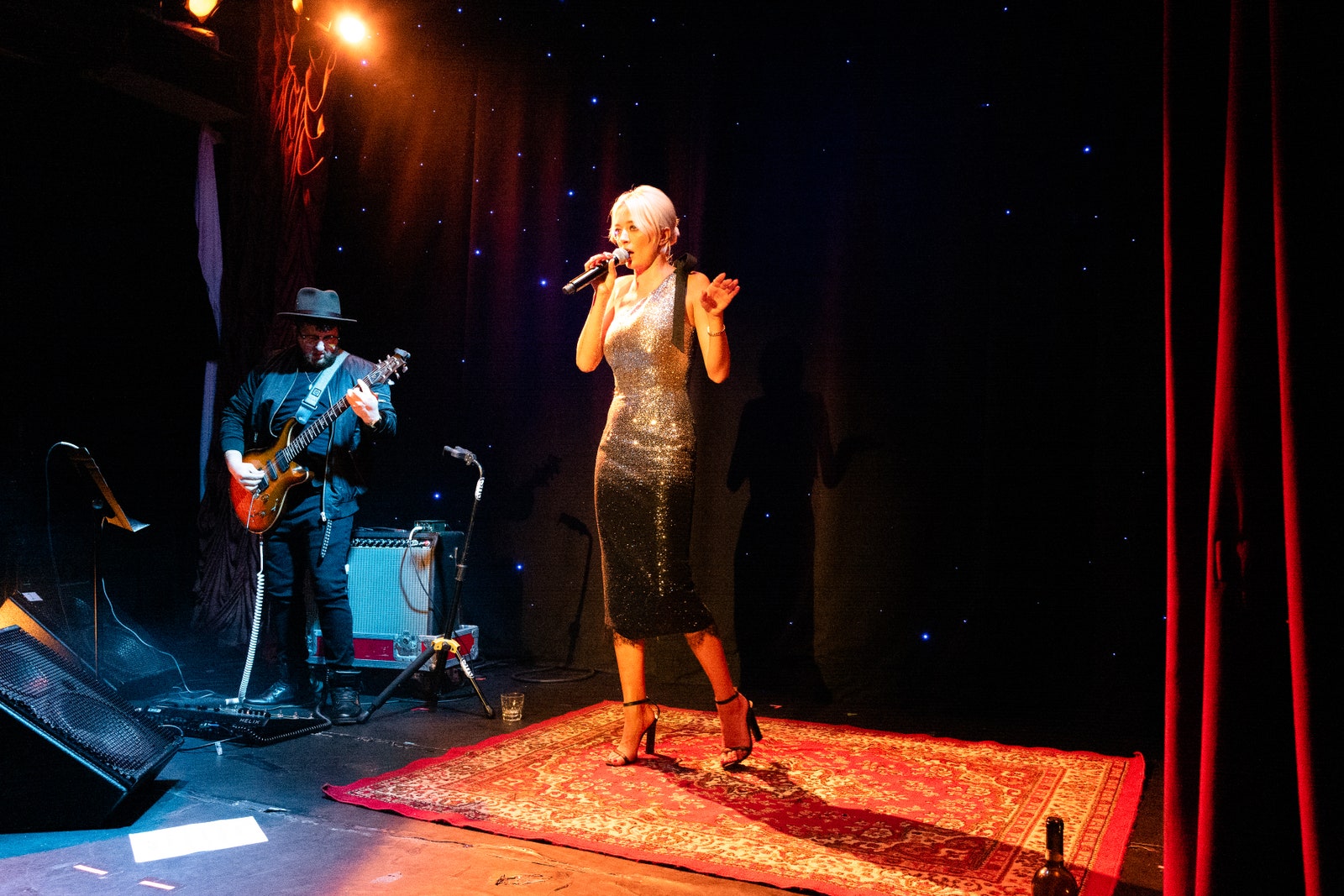 Caroline Vreeland singing onstage beside a guitarist
