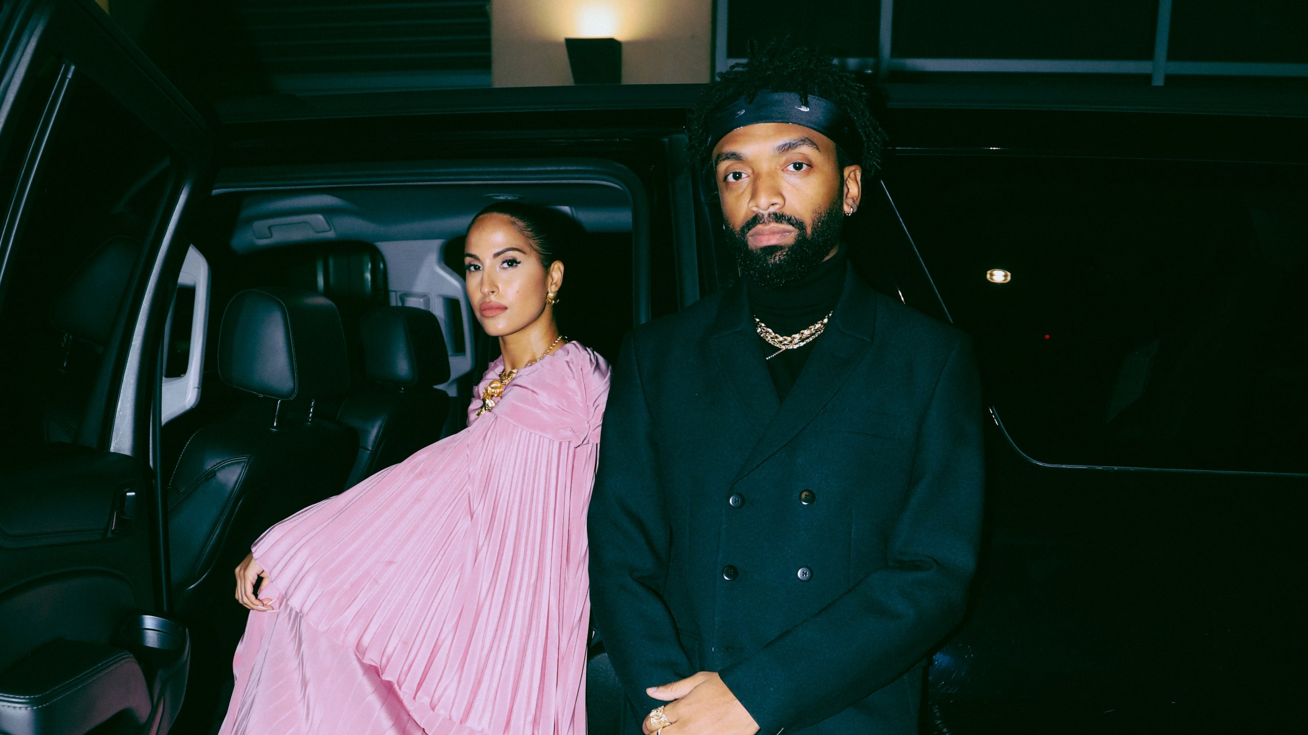 Snoh Aalegra in a pink pleated dress beside designer Kerby Jean-Raymond