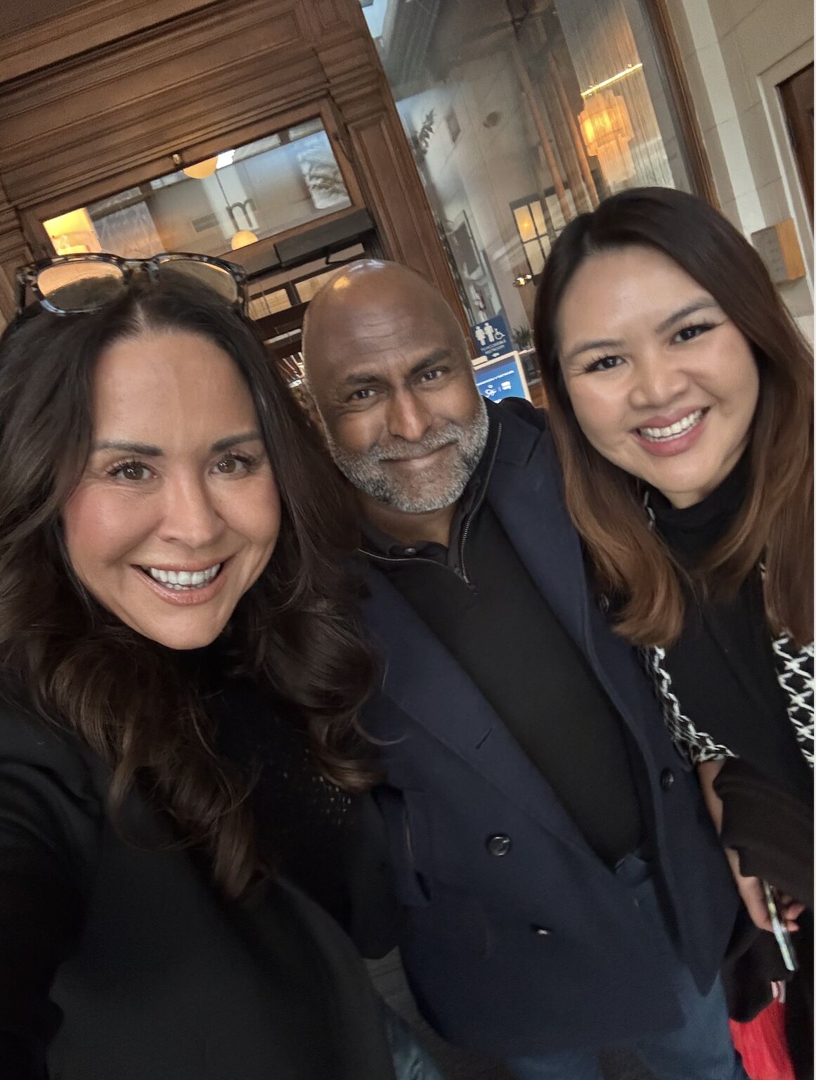 Noel Pugh smiling with two attendees at a San Francisco healthcare gathering