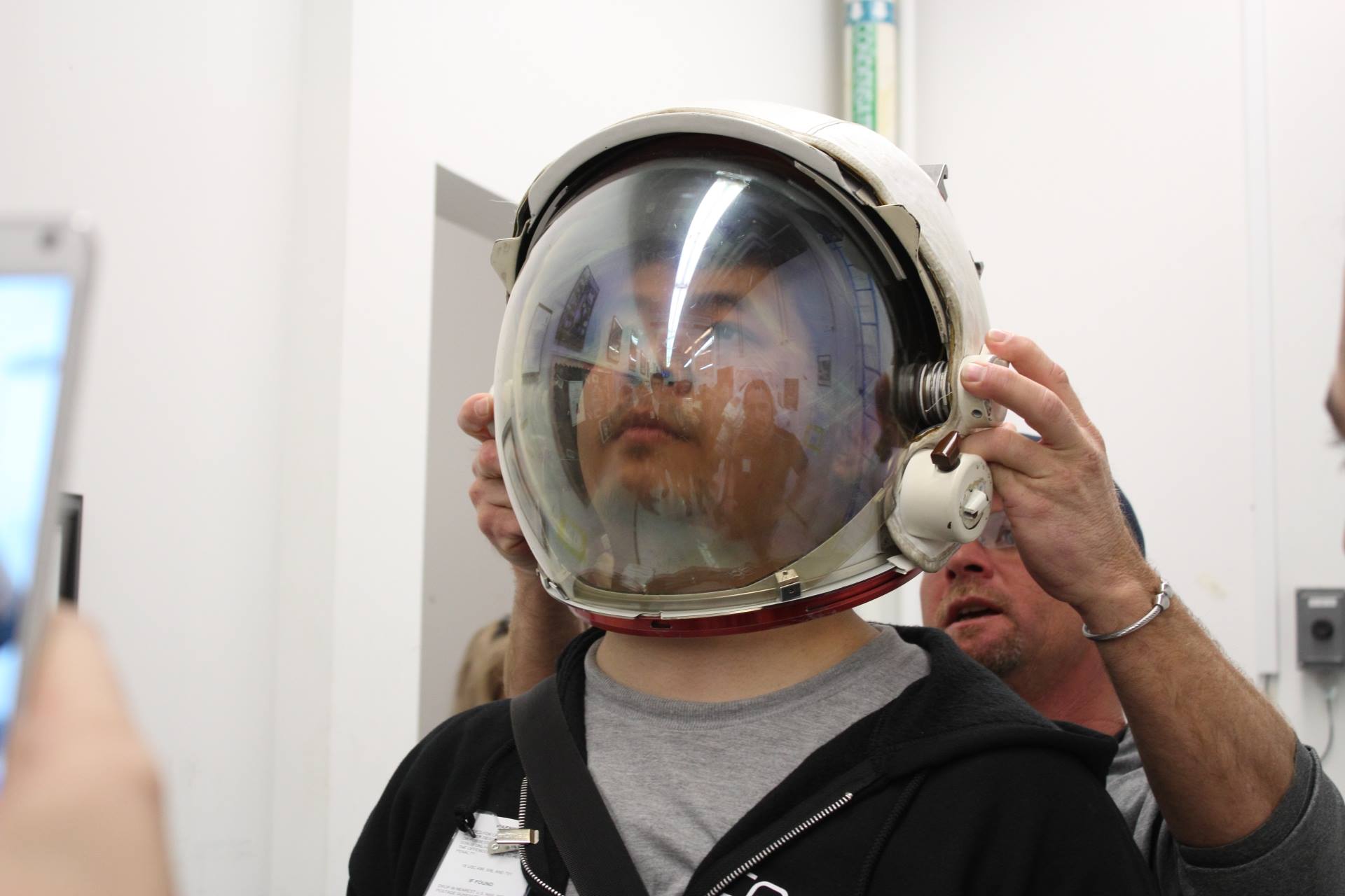 Norman Wang tries on an astronaut helmet during a visit to NASA's Johnson Space Center