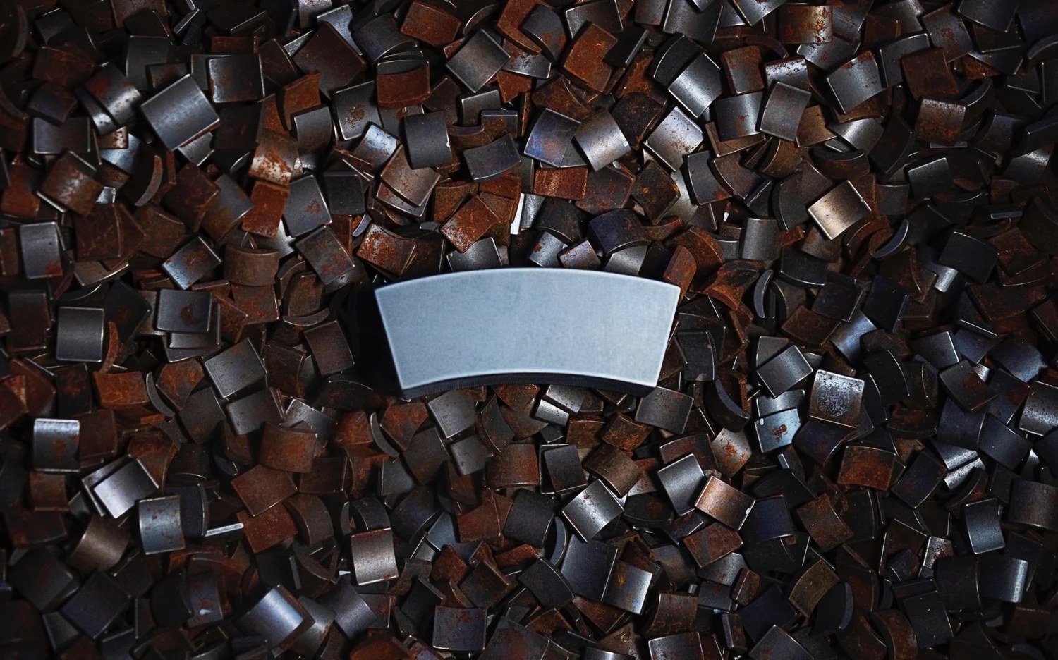 A finished magnet resting on a pile of older magnetic material