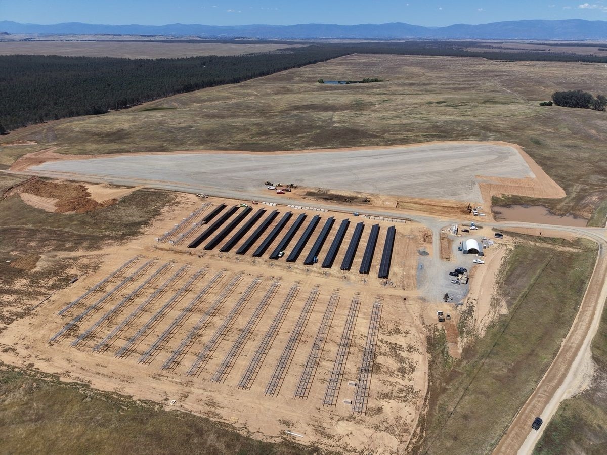Aerial view of the Paskenta tribal microgrid under construction, with rows of solar equipment and mountains beyond