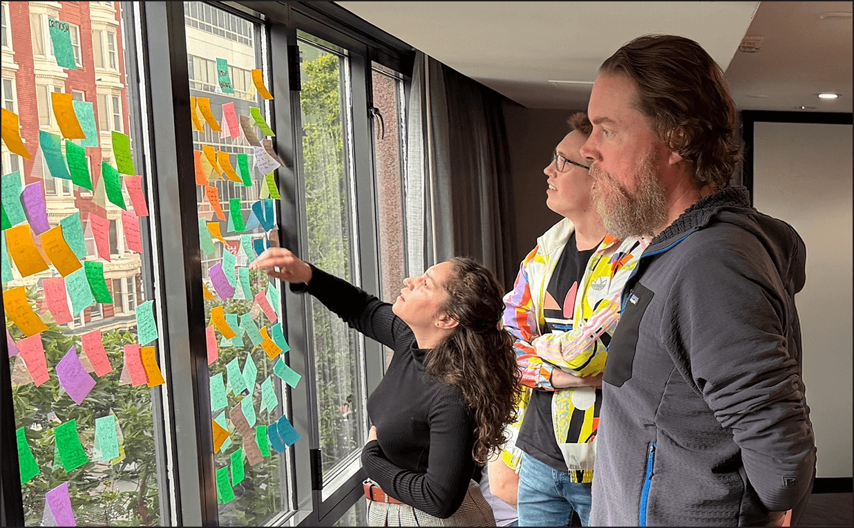 Observable team members reviewing research notes arranged on a window