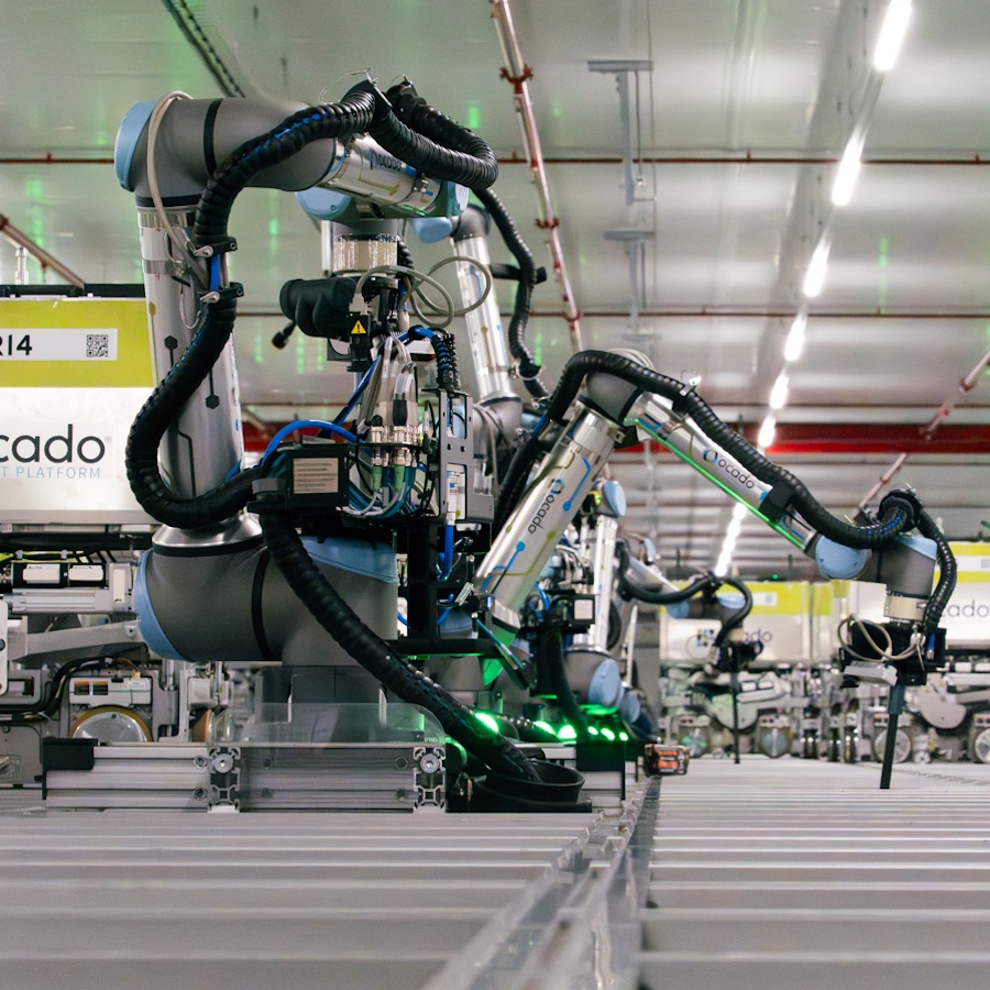 Ocado robotic picking arms working above the warehouse grid