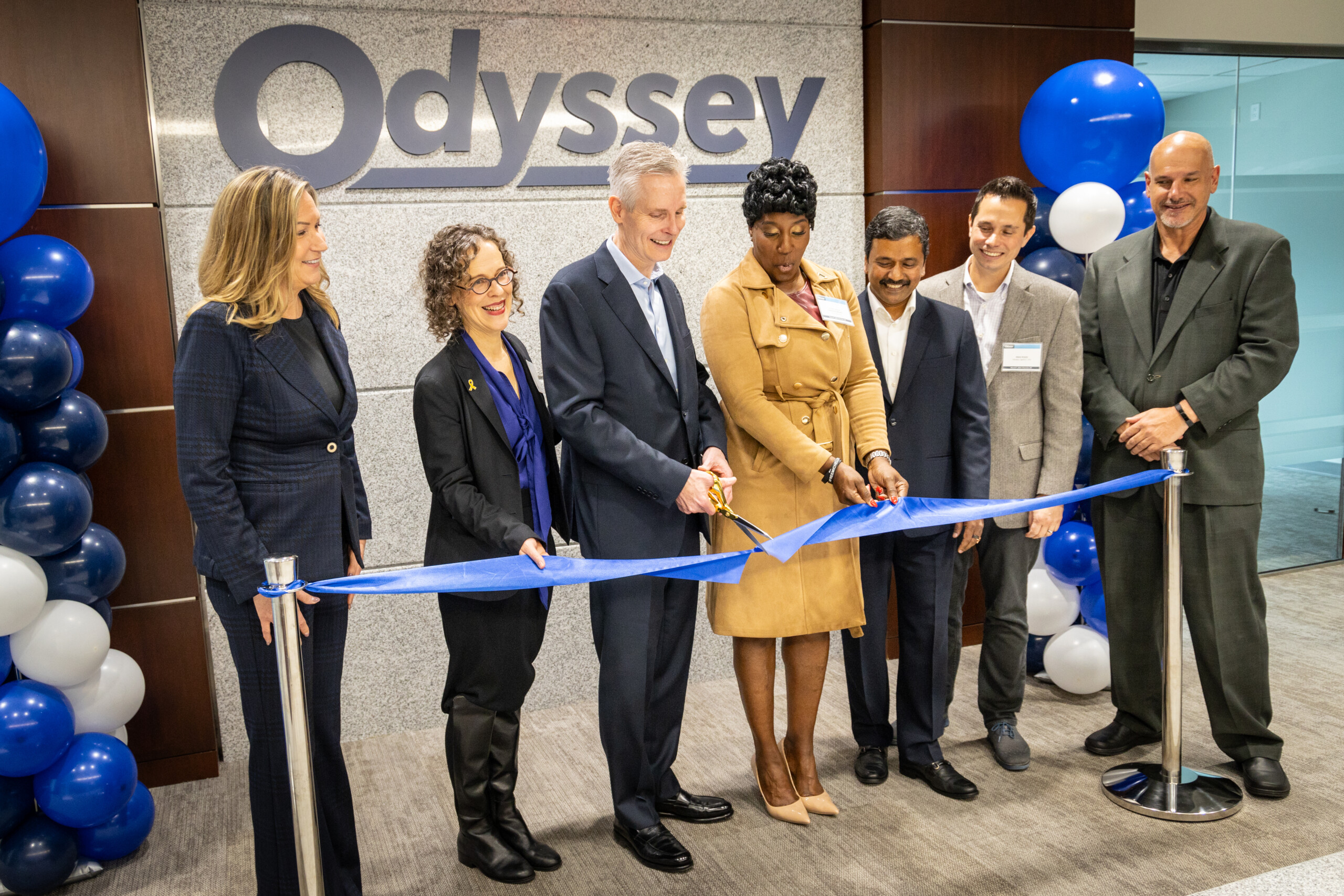 Odyssey executives and local guests cut a ribbon at the Charlotte headquarters opening
