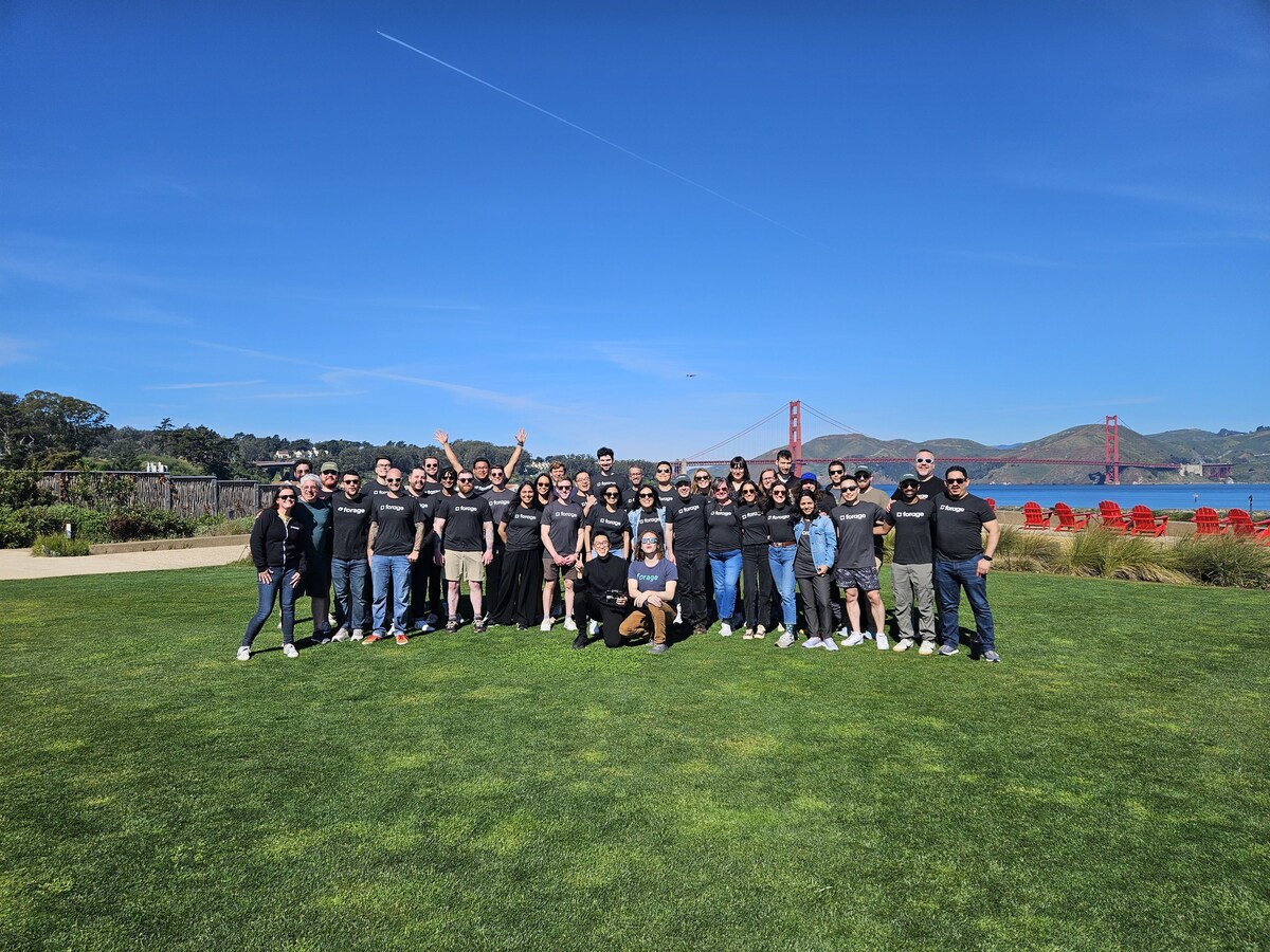 The Forage team gathered on grass beside San Francisco Bay with the Golden Gate Bridge in the distance