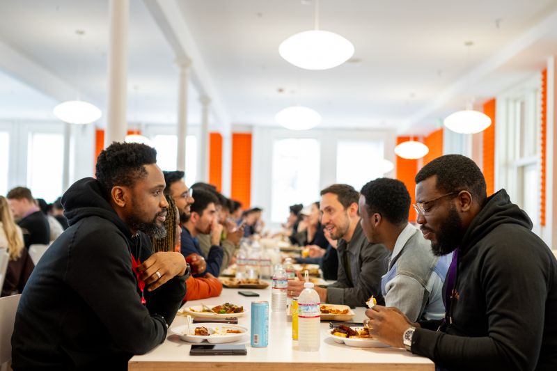 Avworhokai and fellow participants talking across a long table during the YC programme