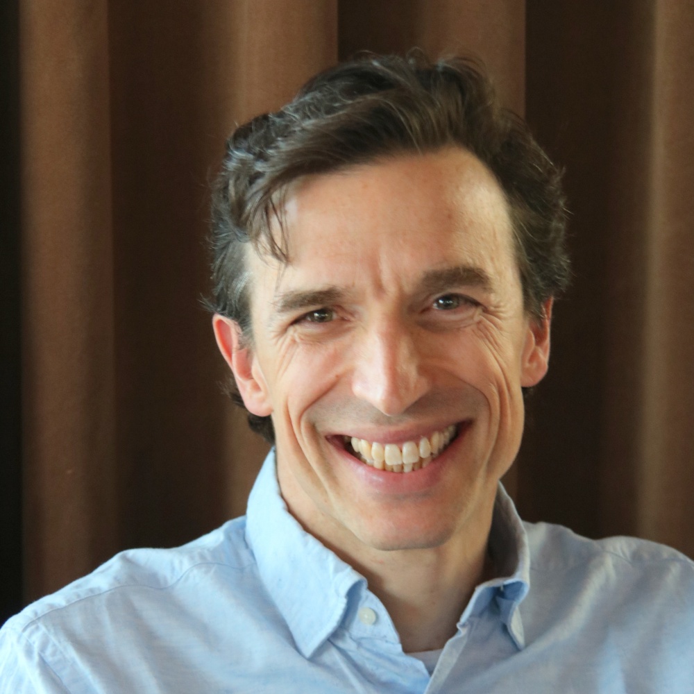 Charles Hipps, Oleeo founder and CEO, smiling in a light blue shirt