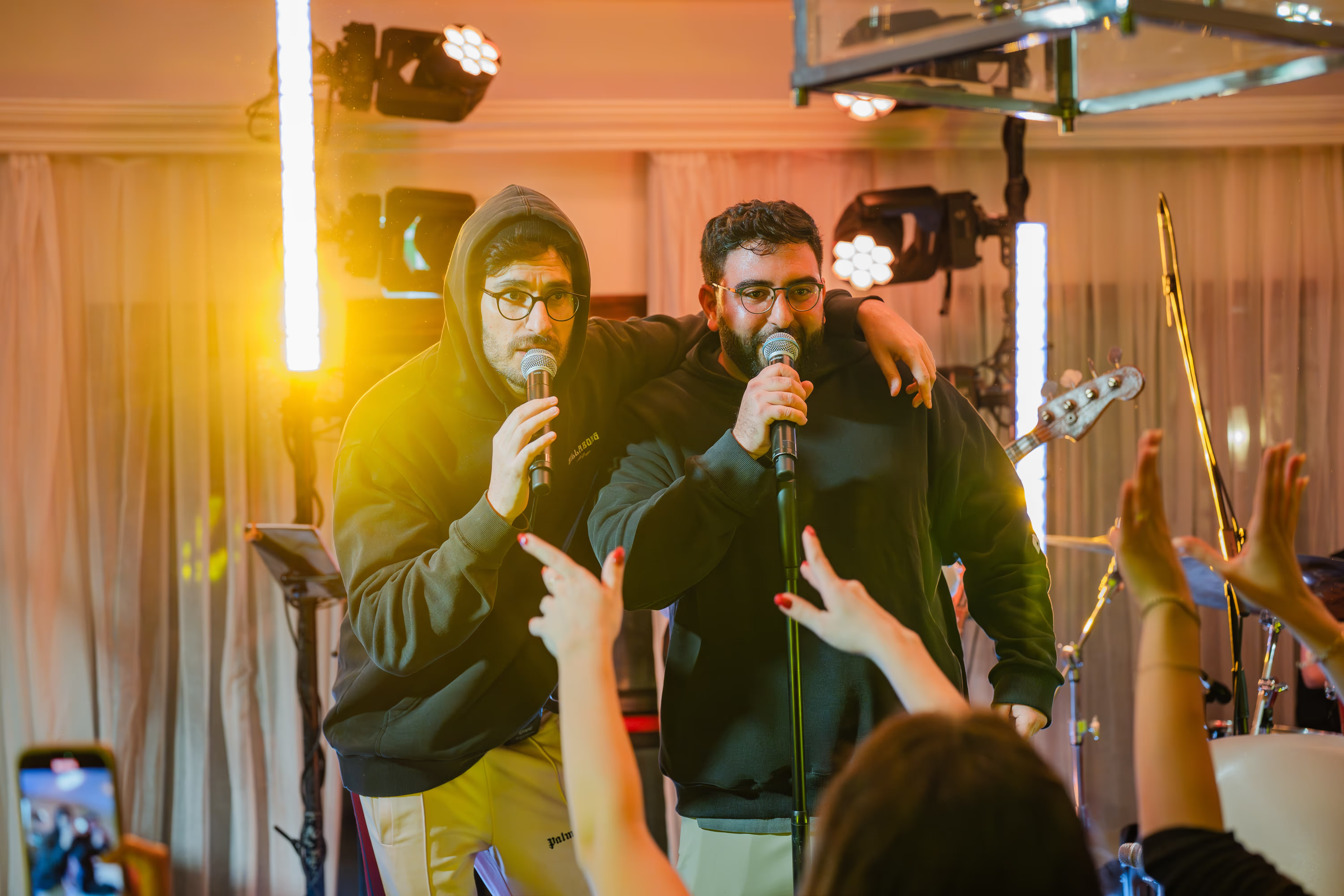 Two participants singing into microphones at an Oligo company event