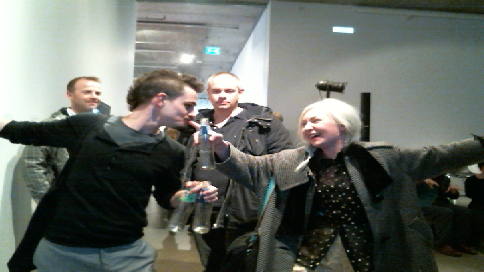 Two visitors reach across the Smooch Booth installation