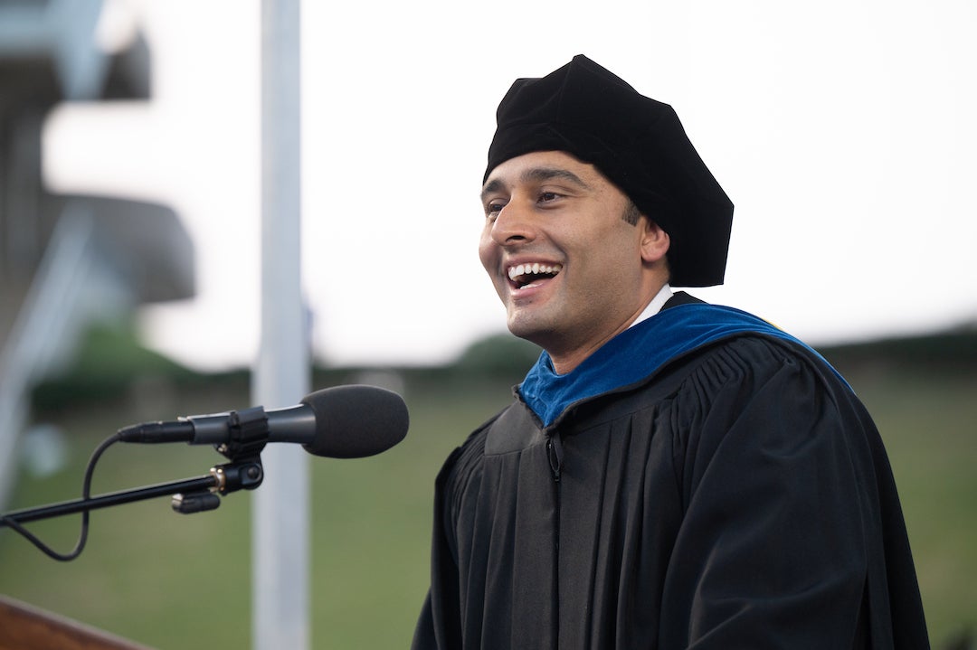 Omair Tariq smiling at the microphone while delivering Rice Business’s 2023 MBA commencement address