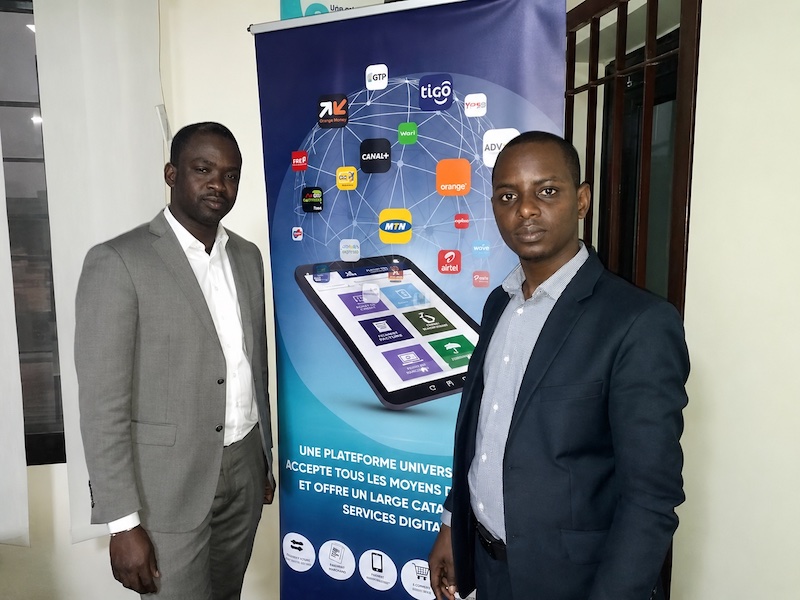 Omar Cissé, on the left, with interviewer Ousmane Gueye beside an InTouch payment-services display