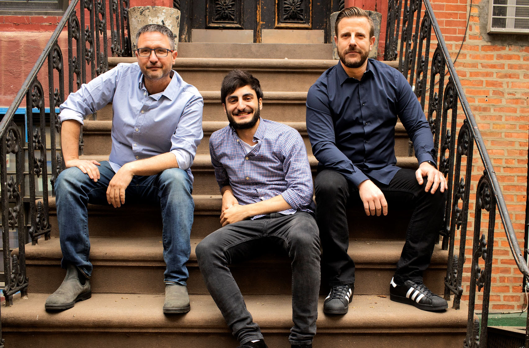 Explorium co-founders Omer Har, Maor Shlomo and Or Tamir seated together on outdoor steps