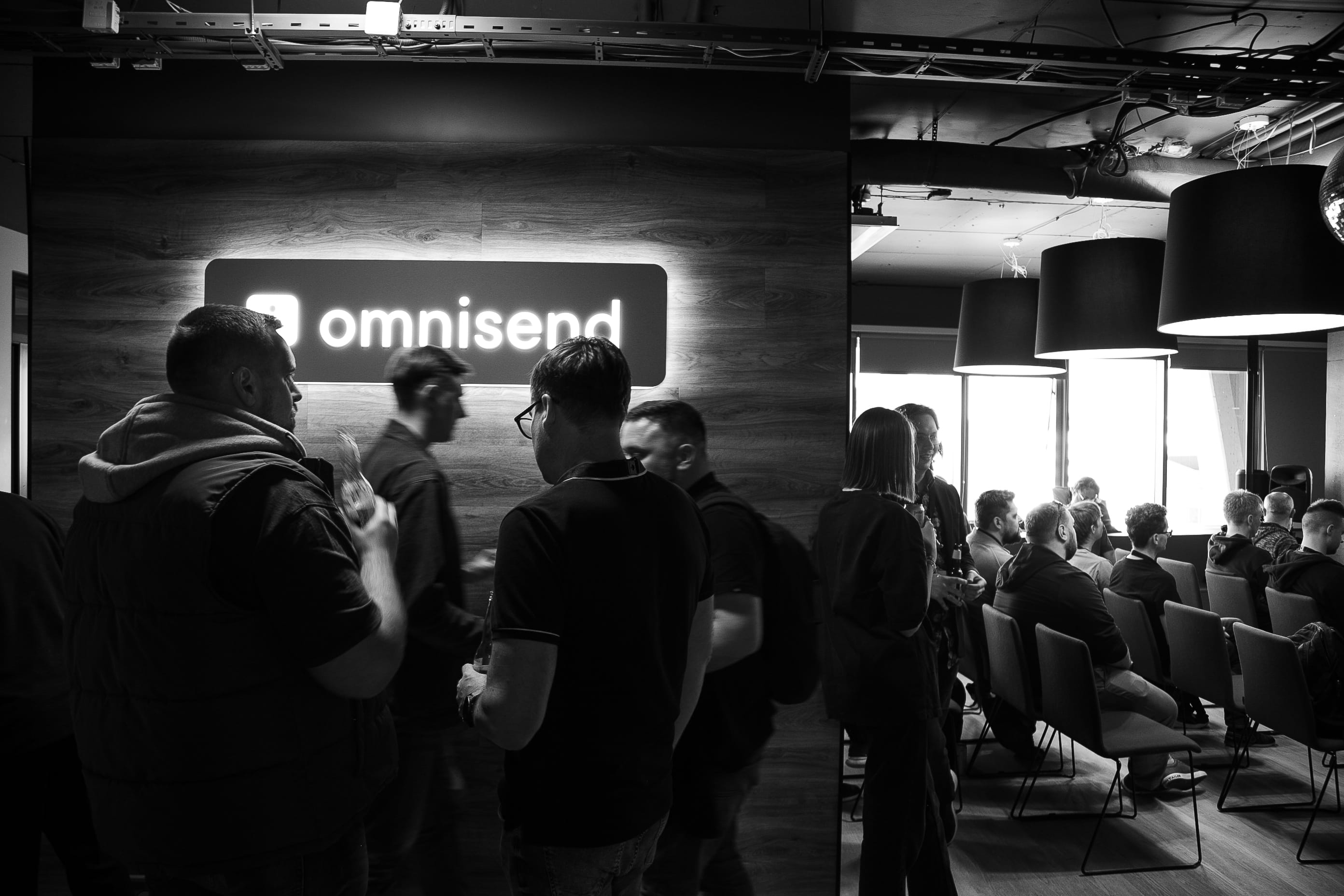 People gathered in an Omnisend office space for a company event