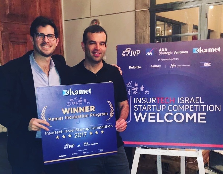 Omri Stern and Michael Rudman holding a winner’s sign at the 2017 InsurTech Israel startup competition