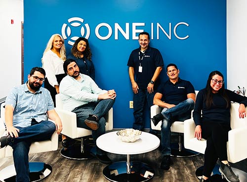One Inc team members standing together at an office event