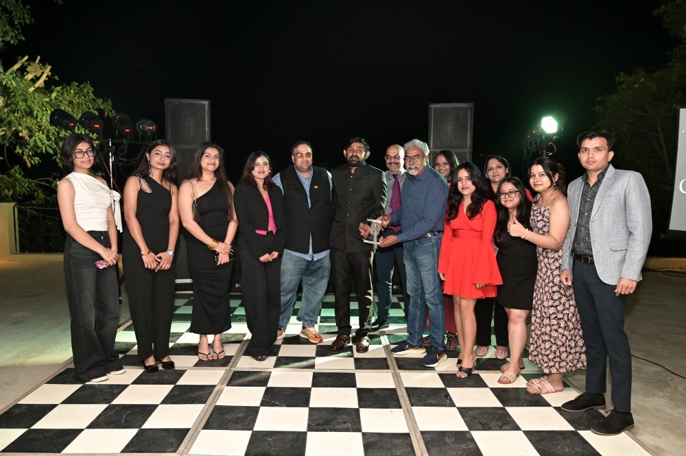 Members of the One Source team standing together at an evening company event