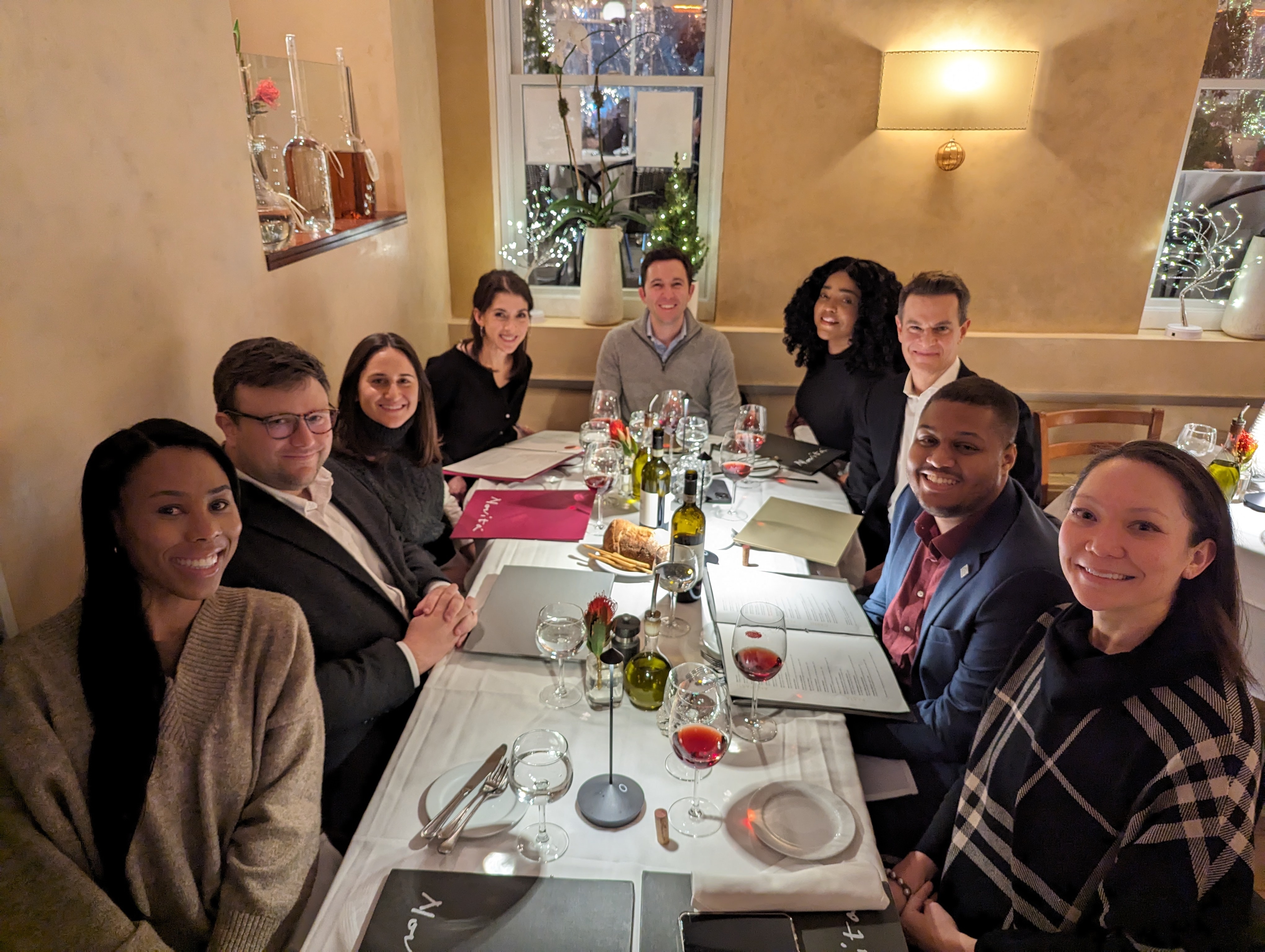 Members of the One Strategy Group team seated around a restaurant table
