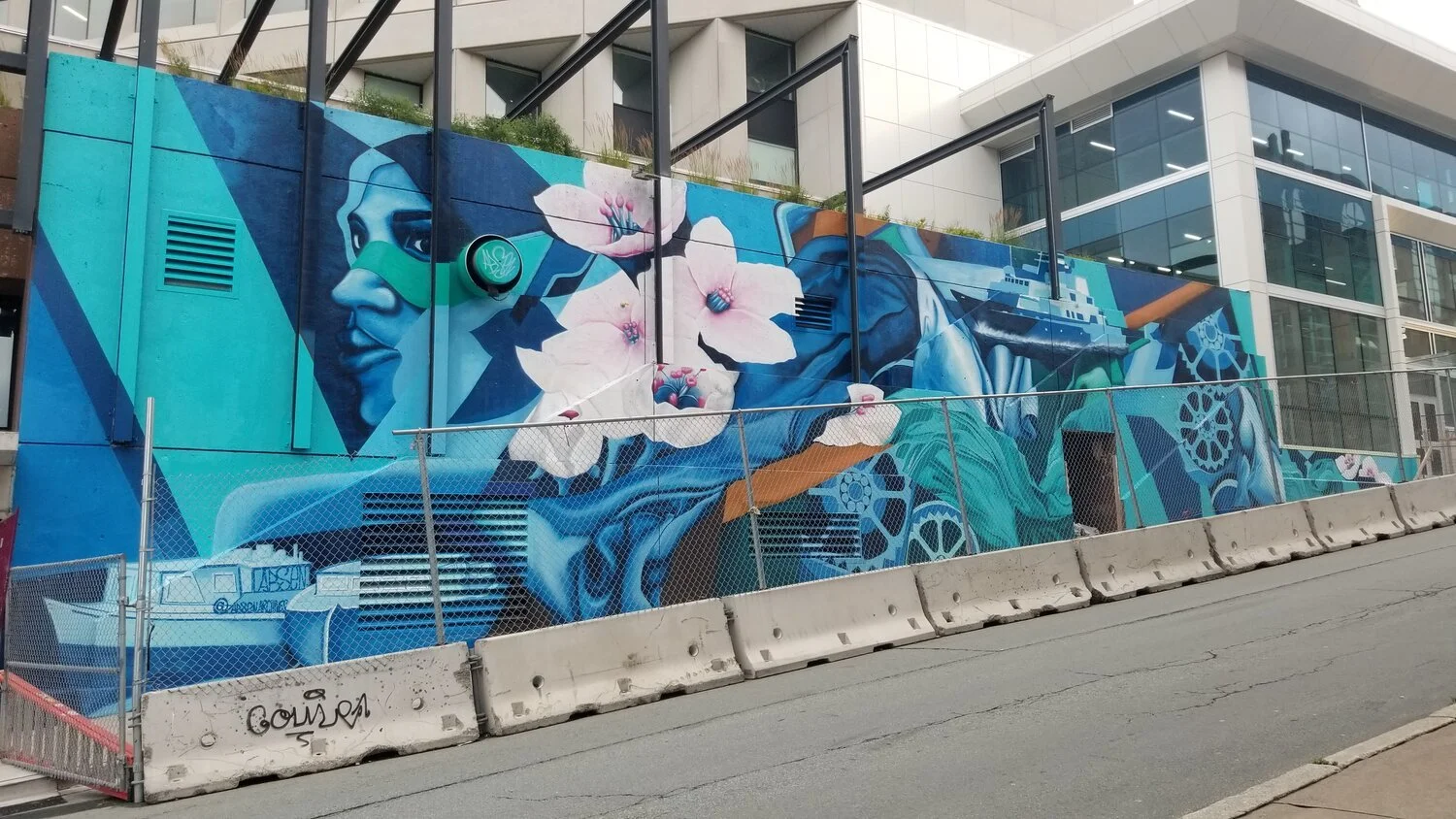 Rising Tides mural showing an engineer, flowers, gears and a boat on a Halifax building